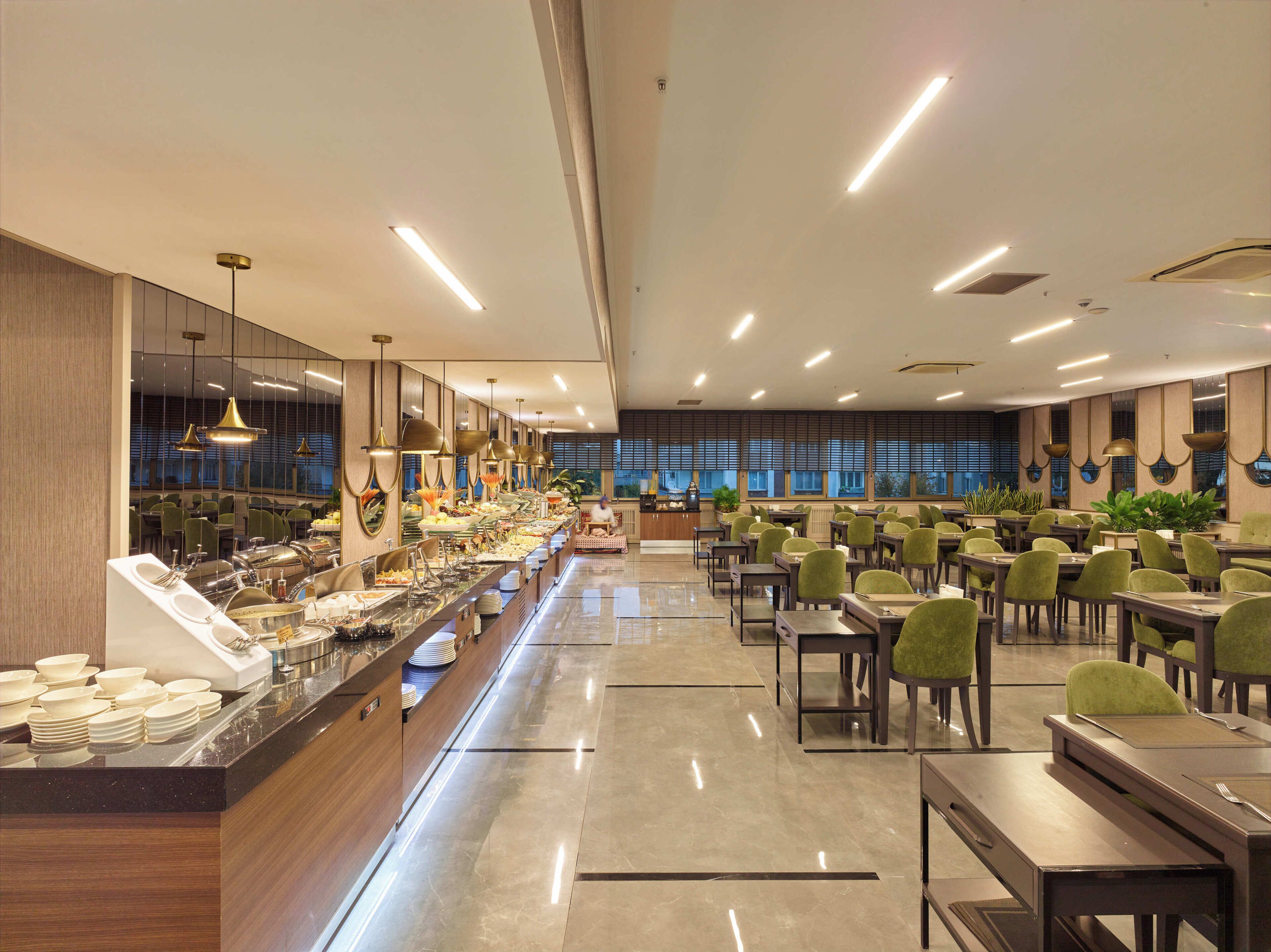 A spacious buffet area with a long counter, multiple seating tables, and a central serving station.