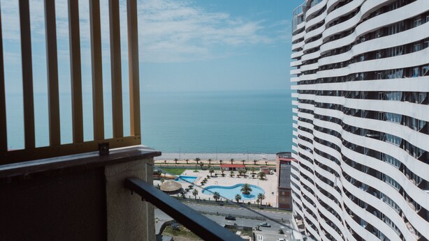 Un hotel de gran altura con vistas al océano y una zona de piscina.