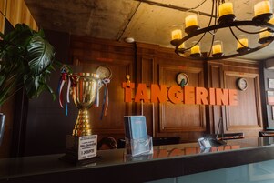 A reception desk with a trophy, a plant, and a sign reading "TANGERINE".