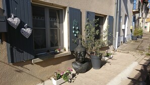 Una casa con persianas oscuras, una estatua de Buda y adornos con forma de corazón.