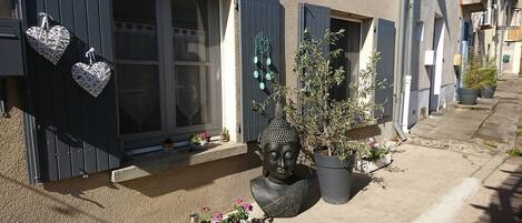 A house with dark shutters, a Buddha statue, and heart-shaped decorations.