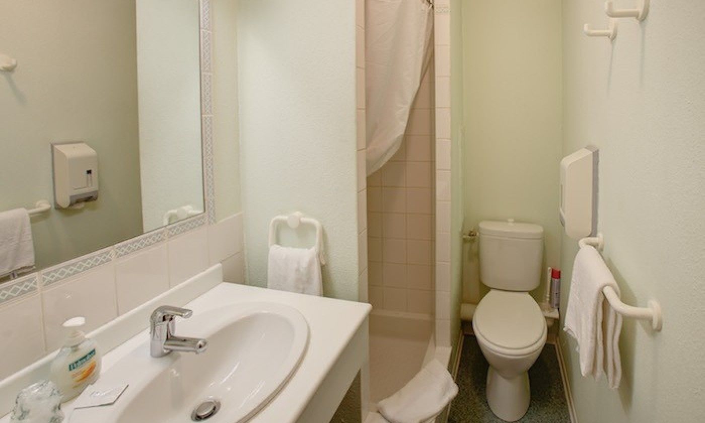 Een badkamer met een wastafel, toilet en douche.