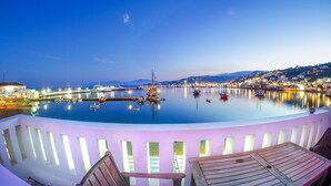 A waterfront view with boats, a pier, and a town in the background. - The Loft Mykonos Town (Mykonos)