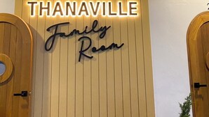 A hotel entrance with a sign reading "THANAVILLE Family Room". - ThanaVill Resort (Mae Sot)