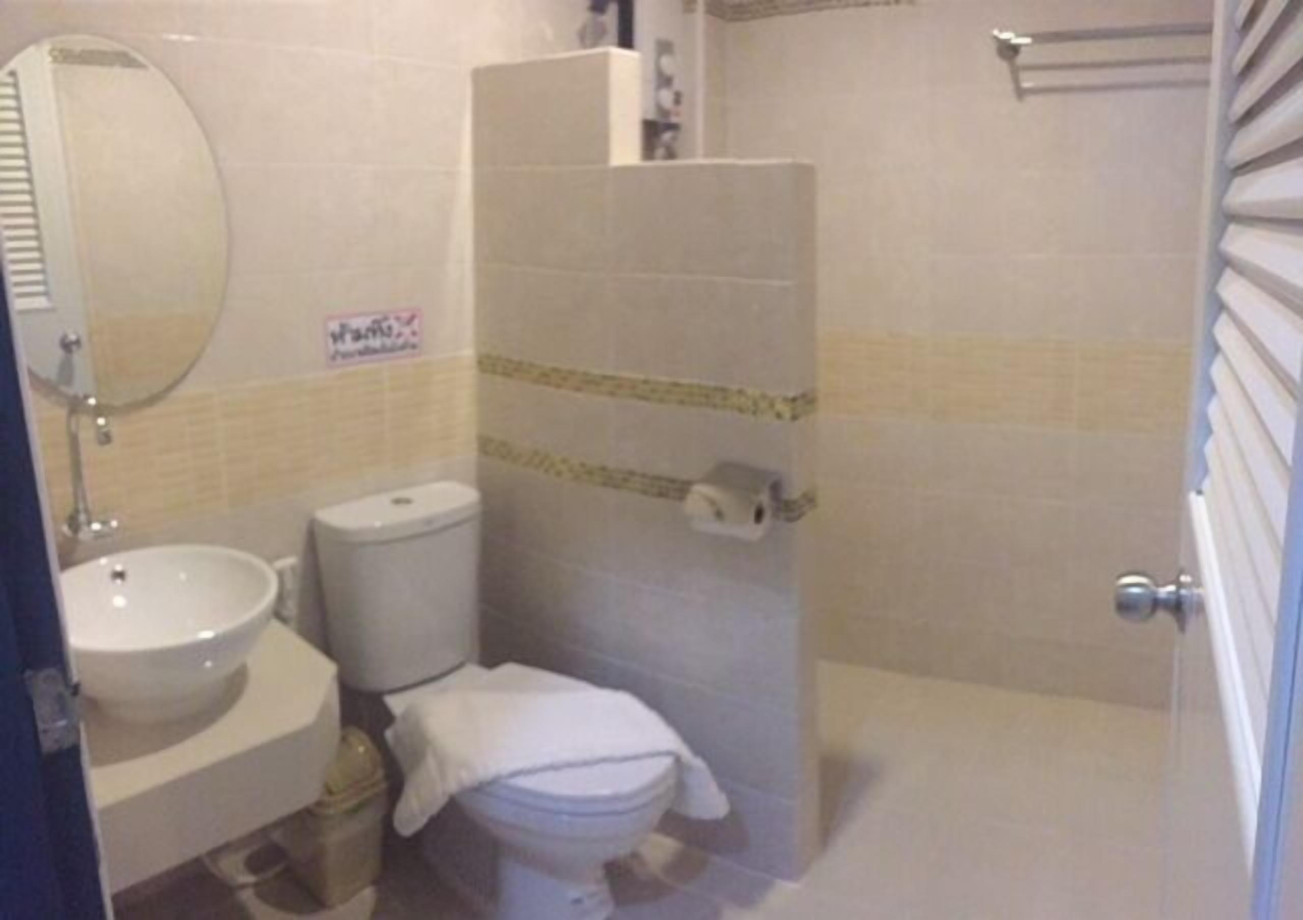 A small bathroom with a sink, toilet, and shower stall.