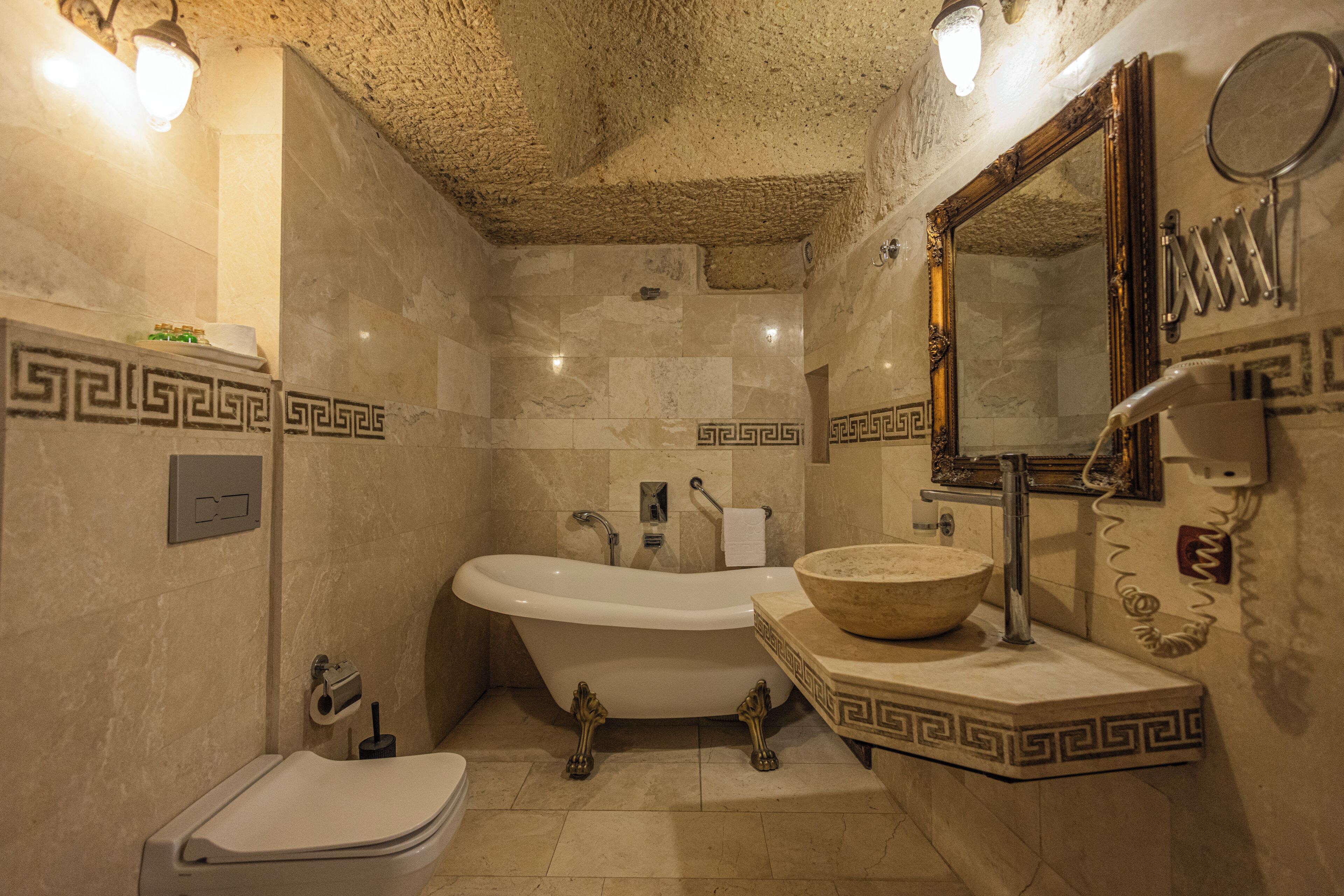 Ein Badezimmer mit einer freistehenden Badewanne, einem Waschbecken, einem Spiegel und einem Handtuchhalter.