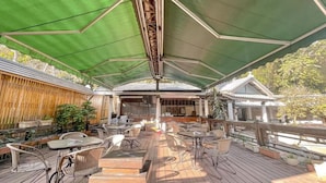 An outdoor patio with wooden flooring, metal chairs, and tables. - Ruixiong Hotspring Villa (Ruisui)