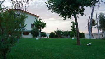 A grassy area with a building, trees, and spherical objects.