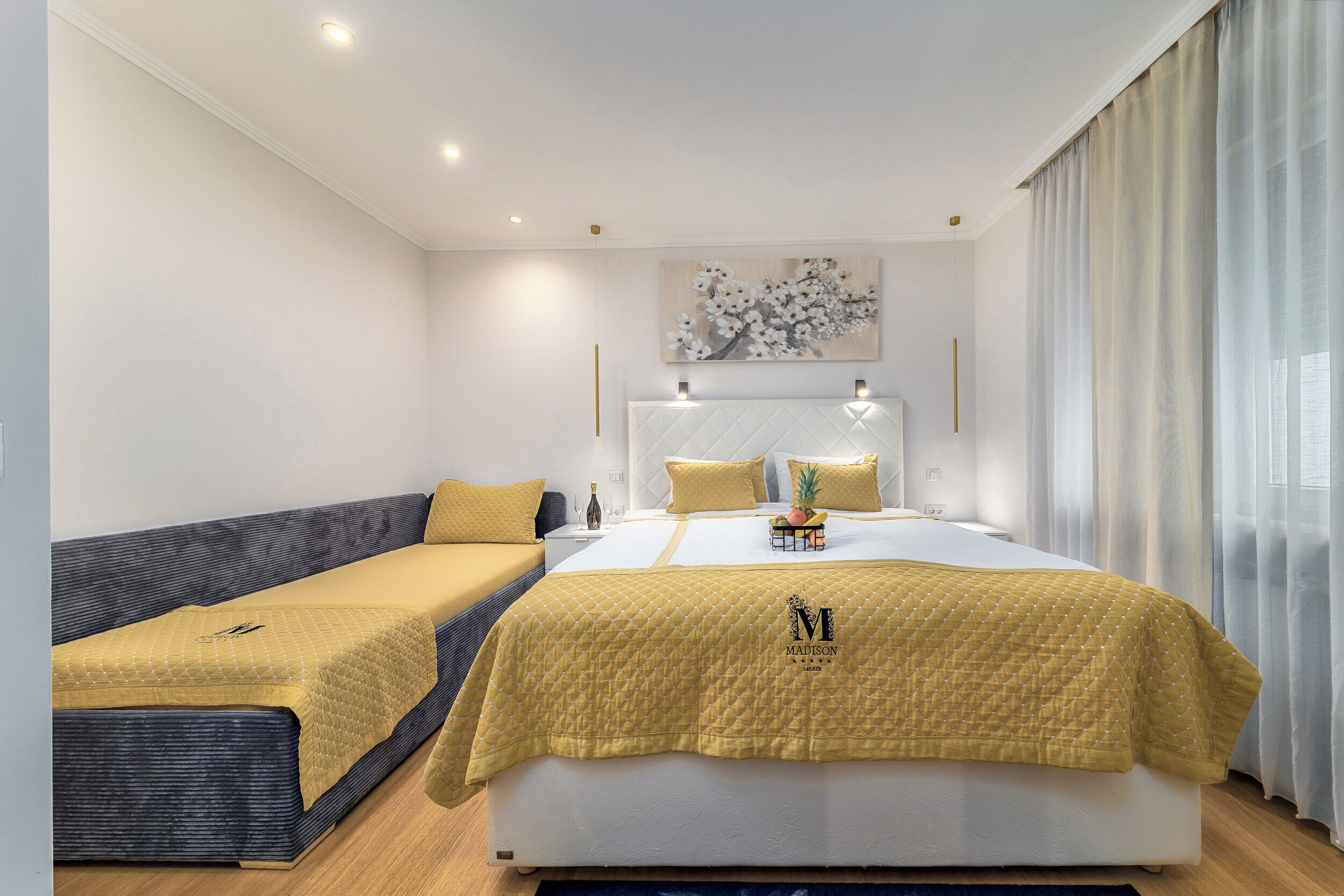 Ein Hotelzimmer mit einem großen Bett, einem kleinen Sofa und einem Gemälde an der Wand.