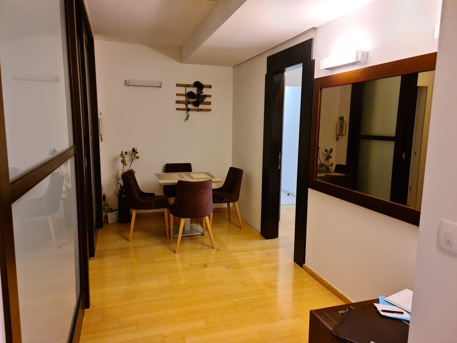 Um espaço compacto com área de jantar, um espelho e uma pequena mesa com cadeiras.