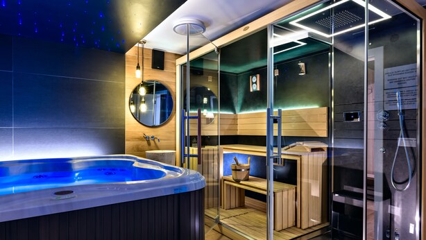 A modern spa room with a hot tub, wooden sauna, and glass-enclosed steam room. - Boutique Hotel Madison (Zagreb)