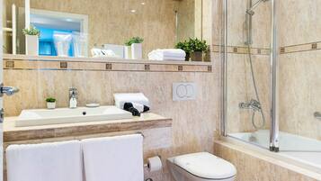 Une salle de bain moderne avec un grand miroir, un lavabo, des toilettes et une douche.