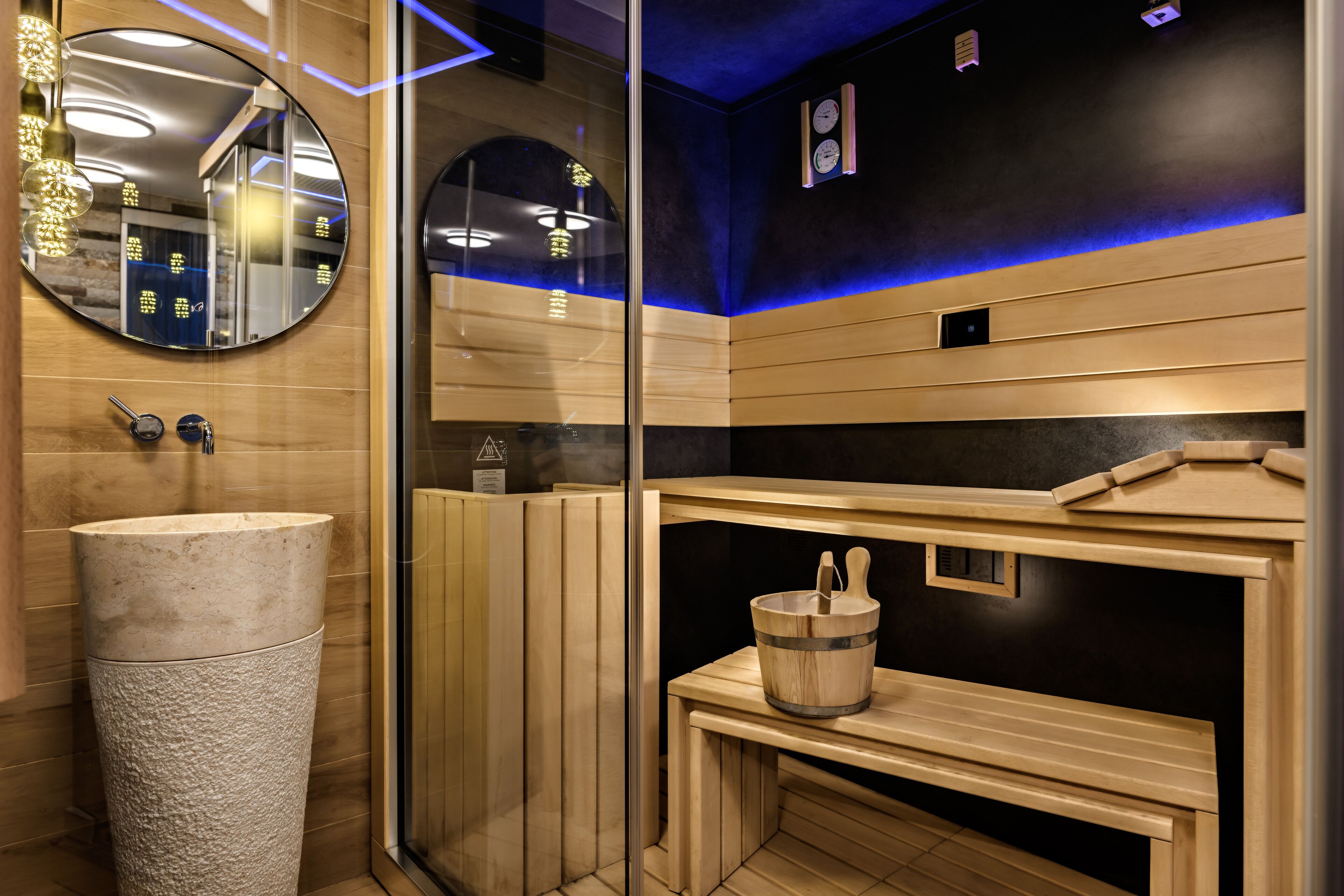 Una sauna con una vasca in pietra, panche di legno e un catino.