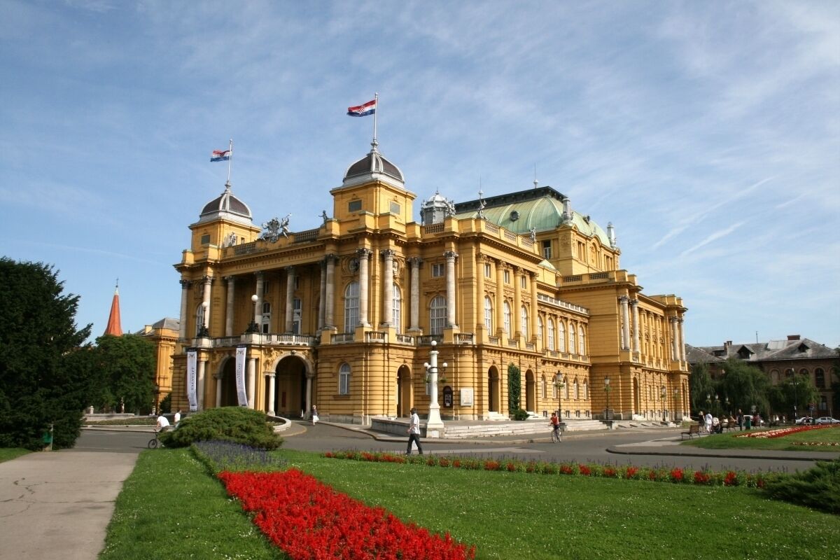 Un grand bâtiment historique à l’architecture classique, doté d’un dôme central et de plusieurs ailes.