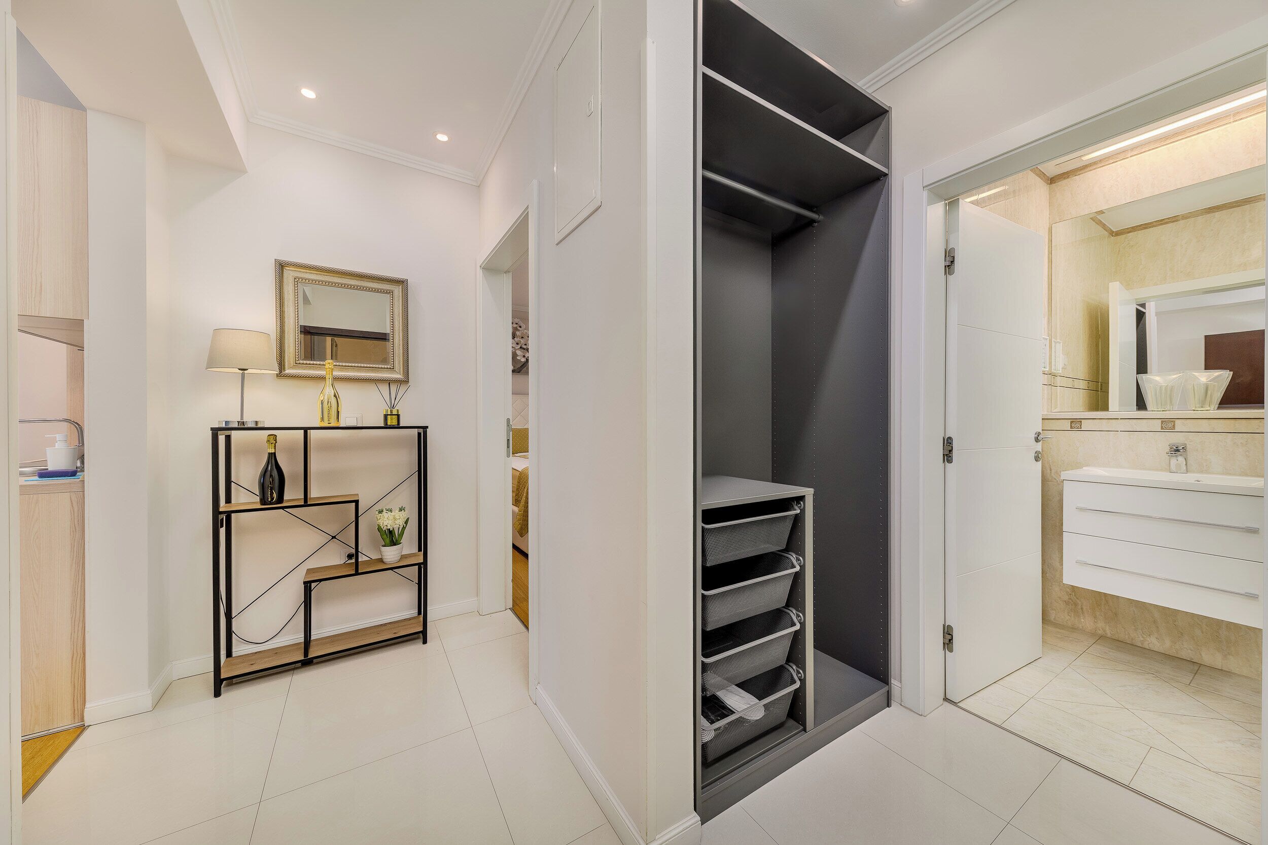 A modern bathroom with a white vanity, a mirror, and a shower area.