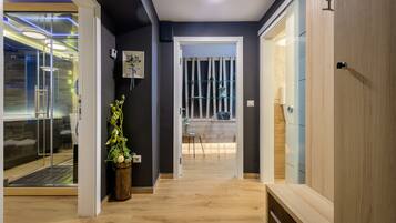 Enjoy a serene space with a glass door leading to a balcony offering a view, a wooden bench, and a small table with a vase of flowers.
