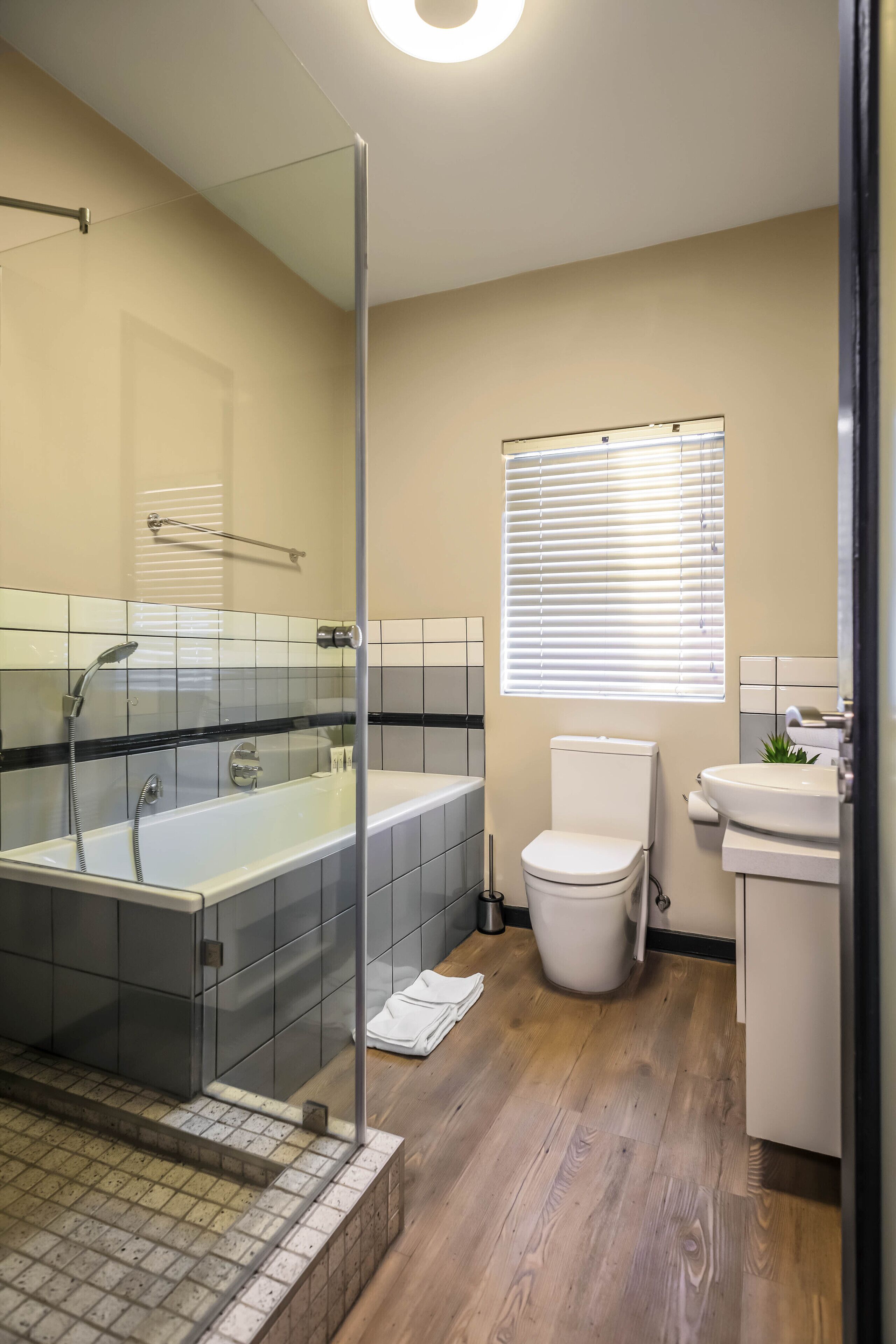 Un bagno moderno con doccia vetrata, una vasca freestanding, un water e un lavandino.