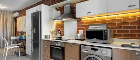 A modern kitchen with stainless steel appliances, a dishwasher, and a built-in oven.