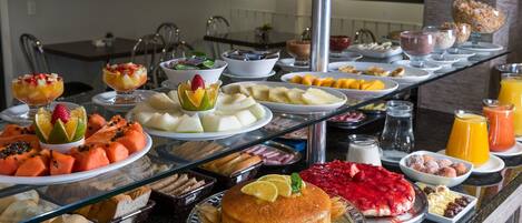 A buffet with various food items including fruits, desserts, and beverages.