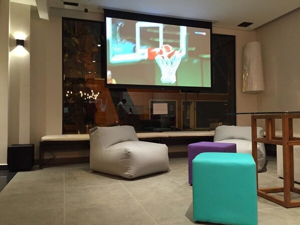 A modern living room with a large flat-screen TV, comfortable seating, and a fireplace. - Ipanema Beach Hostel (Rio de Janeiro)