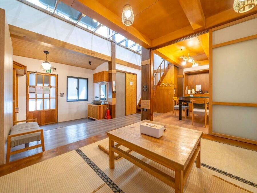 Una habitación tradicional japonesa con suelo de tatami, una mesa de madera baja y una puerta corredera.
