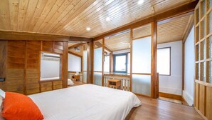 A wooden-paneled bedroom with a bed, a desk, and a window. - Suehirodori Japanese Entire Home No1 (Tainan)