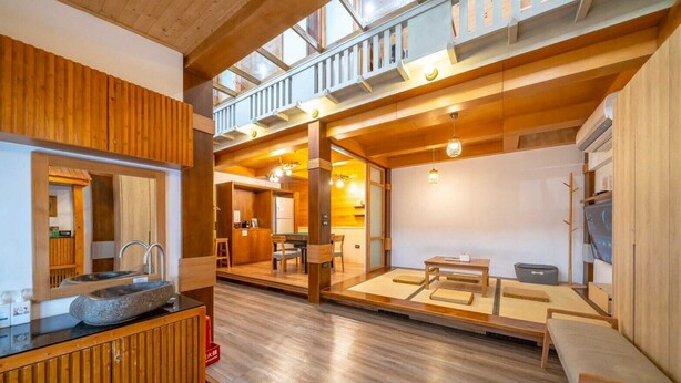 A spacious room with a wooden floor, a stone basin, a wooden cabinet, a dining area with a table and chairs, and a balcony with a railing. - Suehirodori Japanese Entire Home No1 (Tainan)