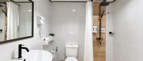 A modern bathroom with a white sink, toilet, and shower area.
