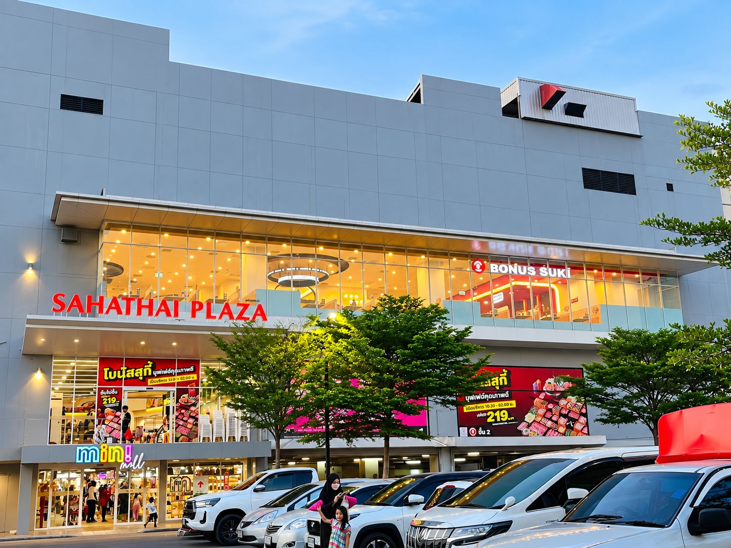 A modern shopping plaza with a prominent sign for 'SAHATHAI PLAZA' and a visible store named 'BONUS SUKI'.