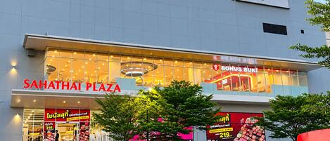 A modern shopping plaza with a prominent sign for 'SAHATHAI PLAZA' and a visible store named 'BONUS SUKI'.