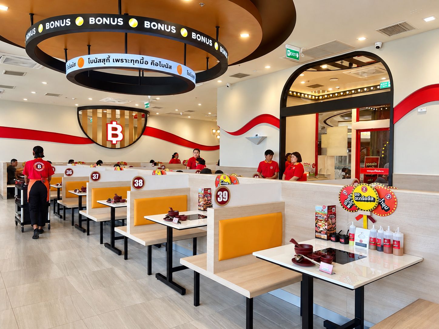 Ein Restaurant mit Sitzecken von 36 bis 39, einem Kassenbereich und einem Werbeschild mit rotem und gelbem Design.