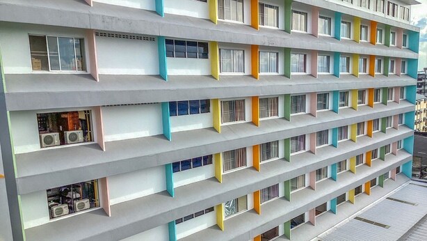 Een meerhoog hotel met balkons en airconditioners.