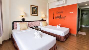 Una habitación de hotel con dos camas, un cuadro en la pared, un equipo de aire acondicionado y un adhesivo mural.