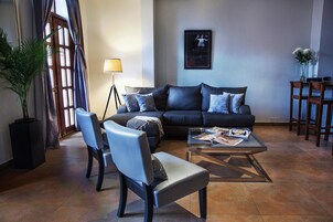A modern living room with a sofa, two armchairs, a coffee table, and a floor lamp.
