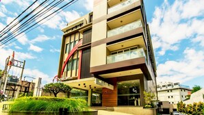 A modern hotel with a multi-story structure, large windows, and a prominent red and brown facade. - Andelir Hotel (Bandung)