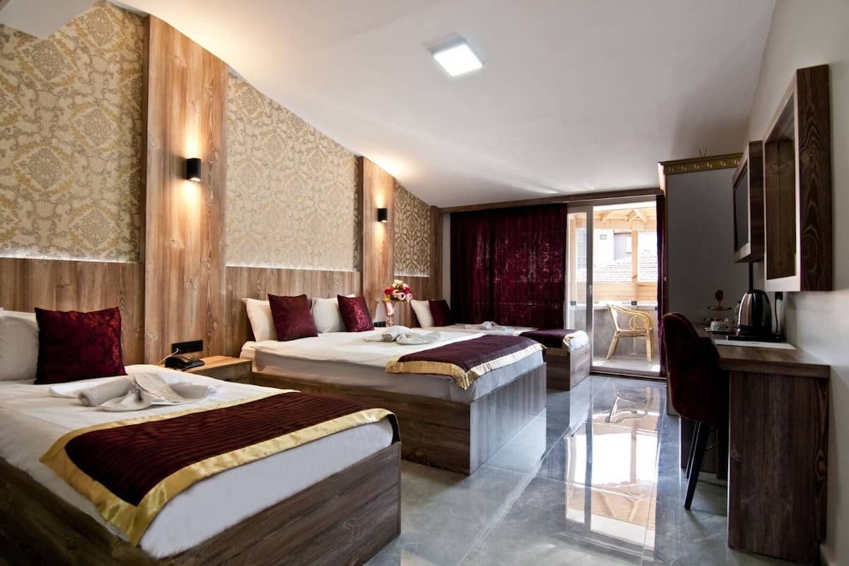 A hotel room with two beds, a desk, and a chair.