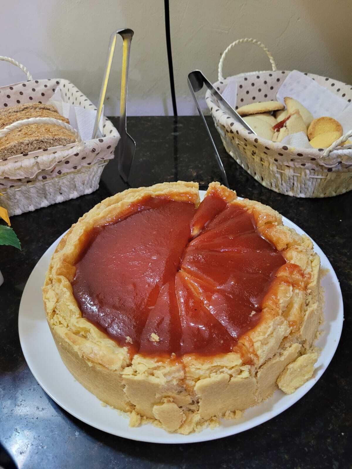 A plate of cherry pie with a lattice crust on a dark countertop.