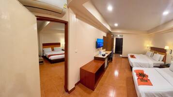 A hotel room with two beds, a TV, a desk, and a bathroom door.