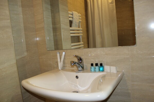 A bathroom with a white sink, a mirror, and a towel rack.
