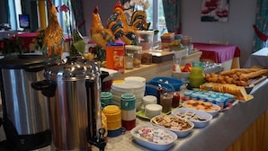 A buffet setup with various food items, condiments, and a coffee maker. - Le Chalet Fleuri (Chauvigny)