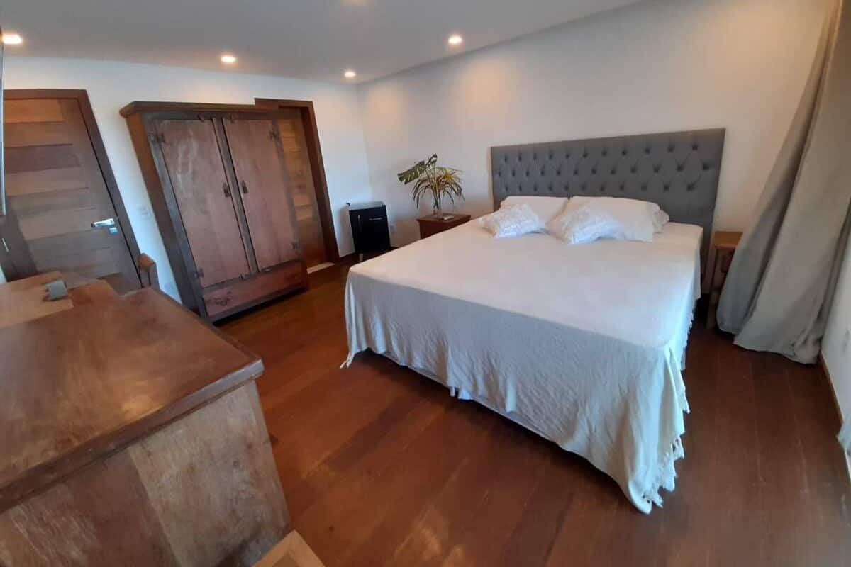 Un dormitorio con una cama grande, un armario de madera y un escritorio.