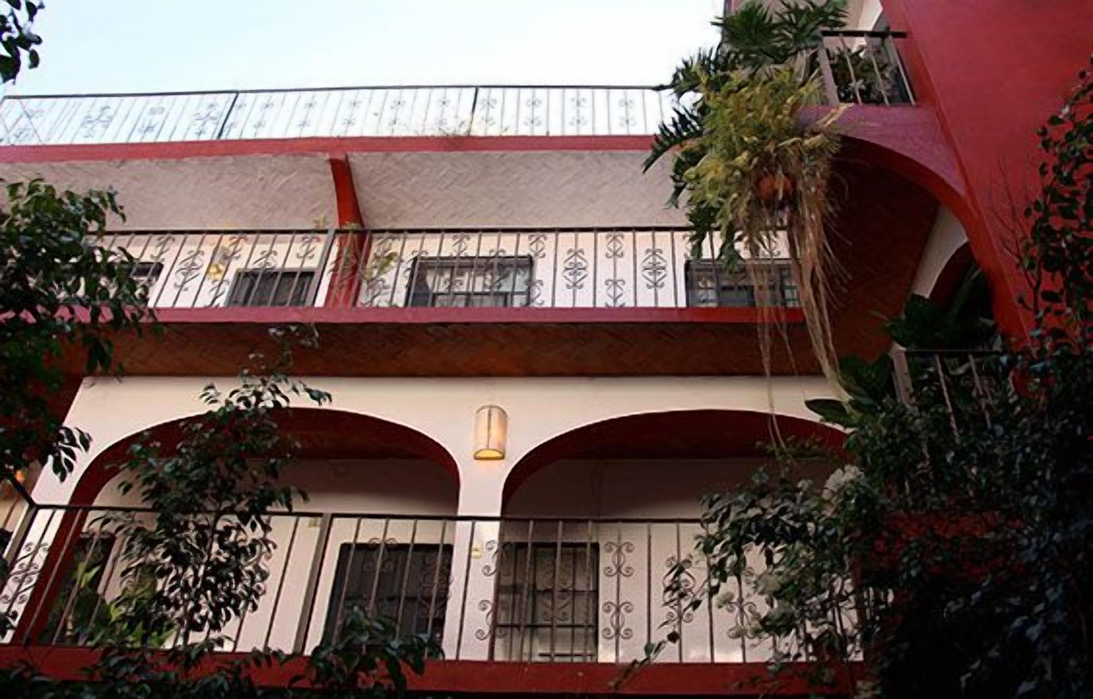 Un edificio de varios pisos con balcones, ventanas arqueadas y barandillas decorativas.