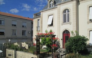 A two-story building with a red door and a balcony.