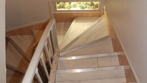 A wooden staircase with white railings and a small window at the top. - Beausejour Hotel (Chauvigny)