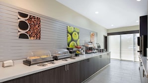 A modern breakfast bar with a variety of food options, including a coffee station and a fruit display. - La Quinta Inn & Suites by Wyndham Lake Charles - Westlake (Westlake)