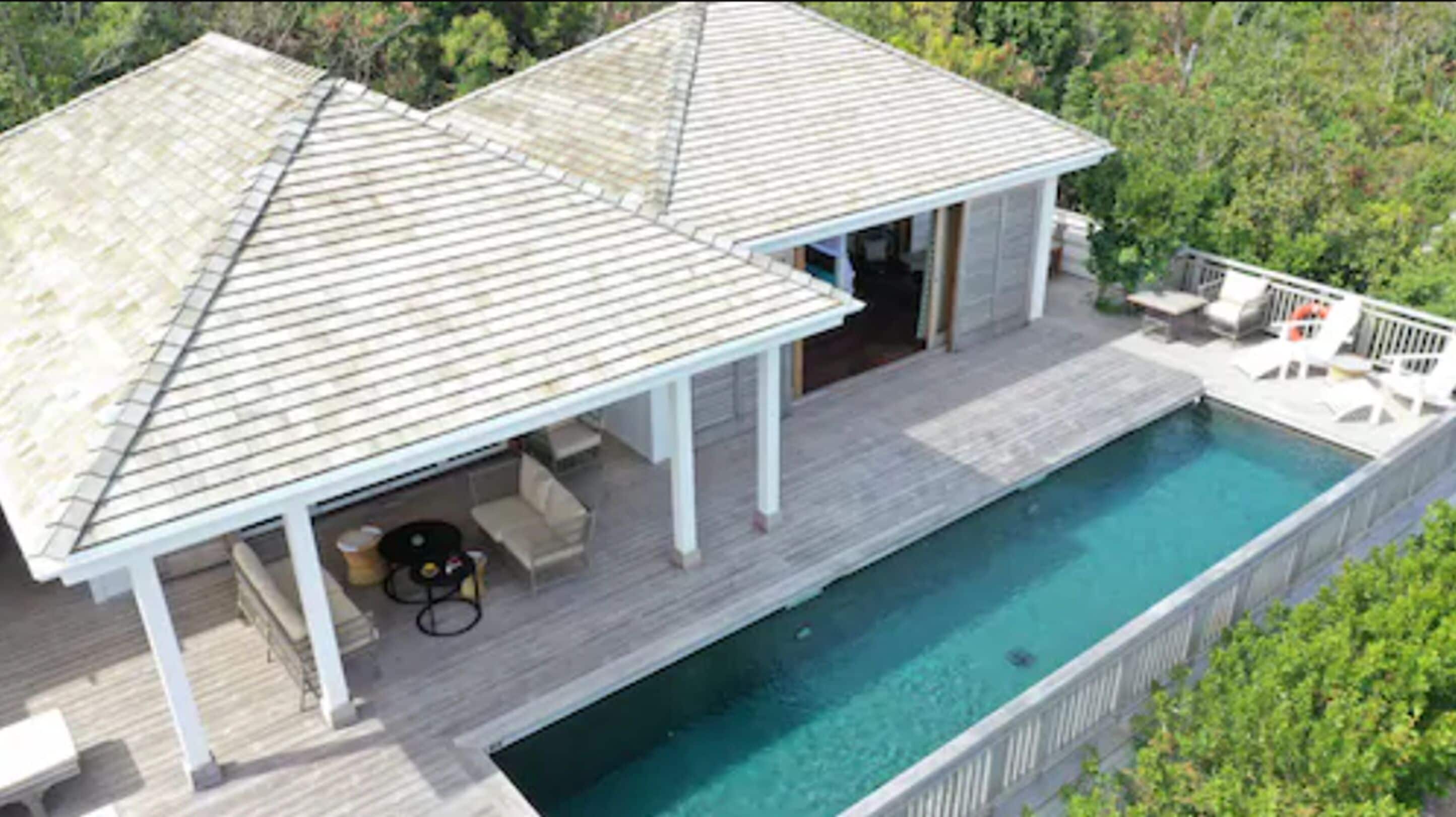 A two-story house with a covered patio and a swimming pool.