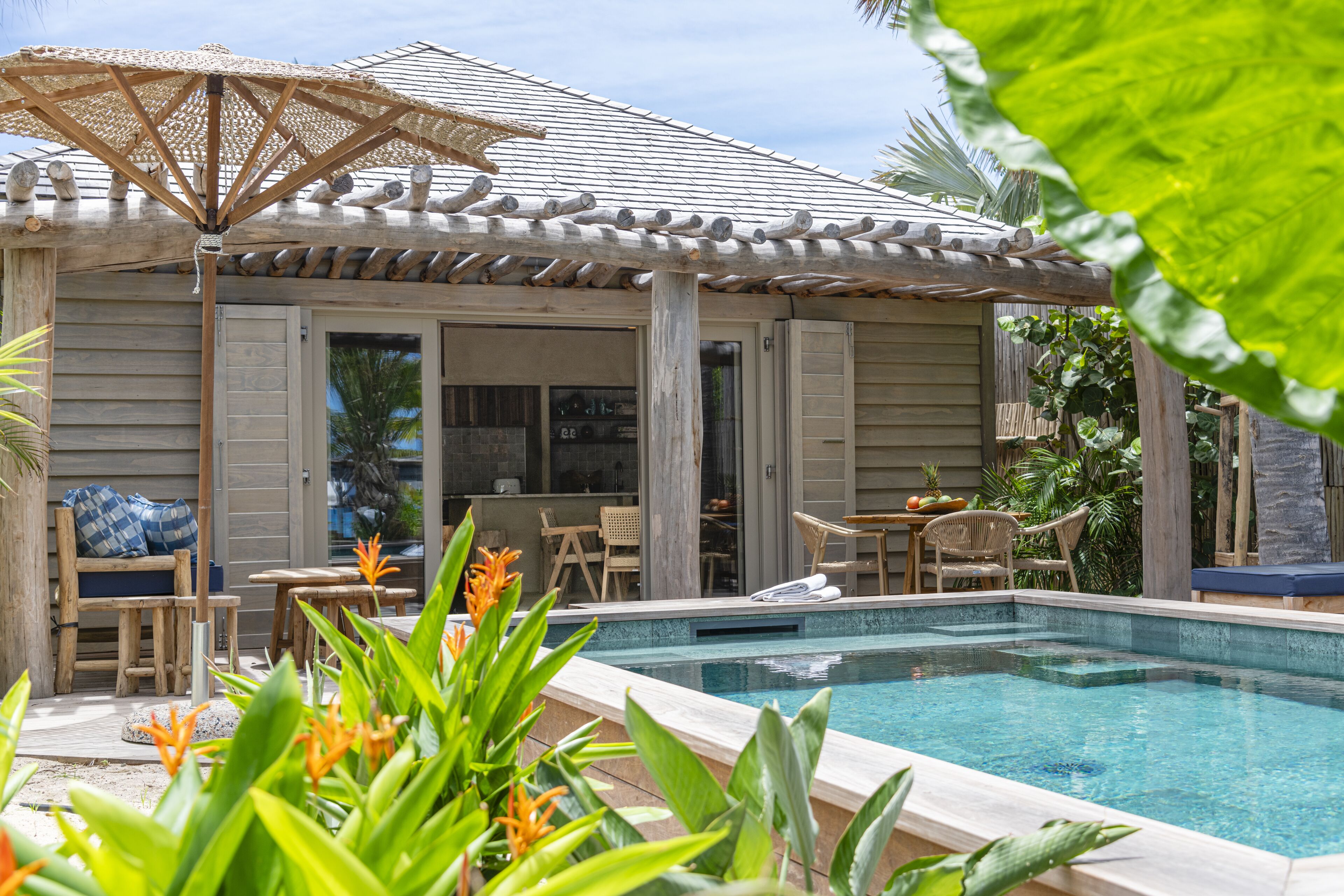 A poolside area with a pergola, outdoor seating, and a view of the pool.