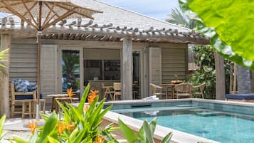 Zona de piscina con pérgola, mobiliario exterior y vistas a la piscina.