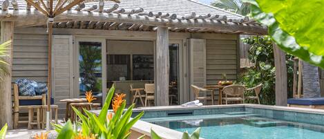 A poolside area with a pergola, outdoor seating, and a view of the pool.