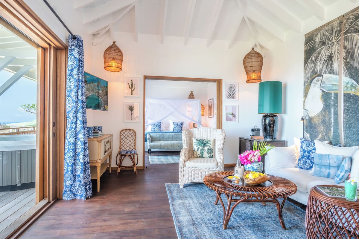 Un salón acogedor con un sofá de mimbre, una mesa de centro con flores y vistas al balcón.